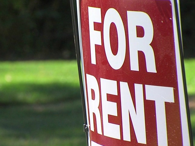 Red For Rent Sign With Green Grass In Background