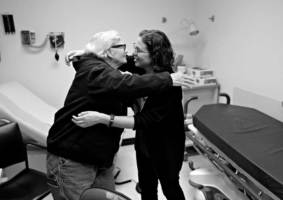 Two Women Wearing Glasses Hugging In A Hospital Room In Black And White In San Francisco