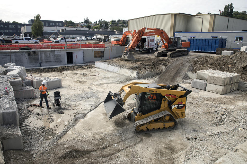 Seattle's Homeless Population Housing Being Built With A Cat Lift In Gravel Pit